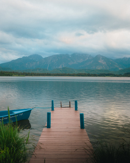 Wooden dock extending into a lake with mountains in the background